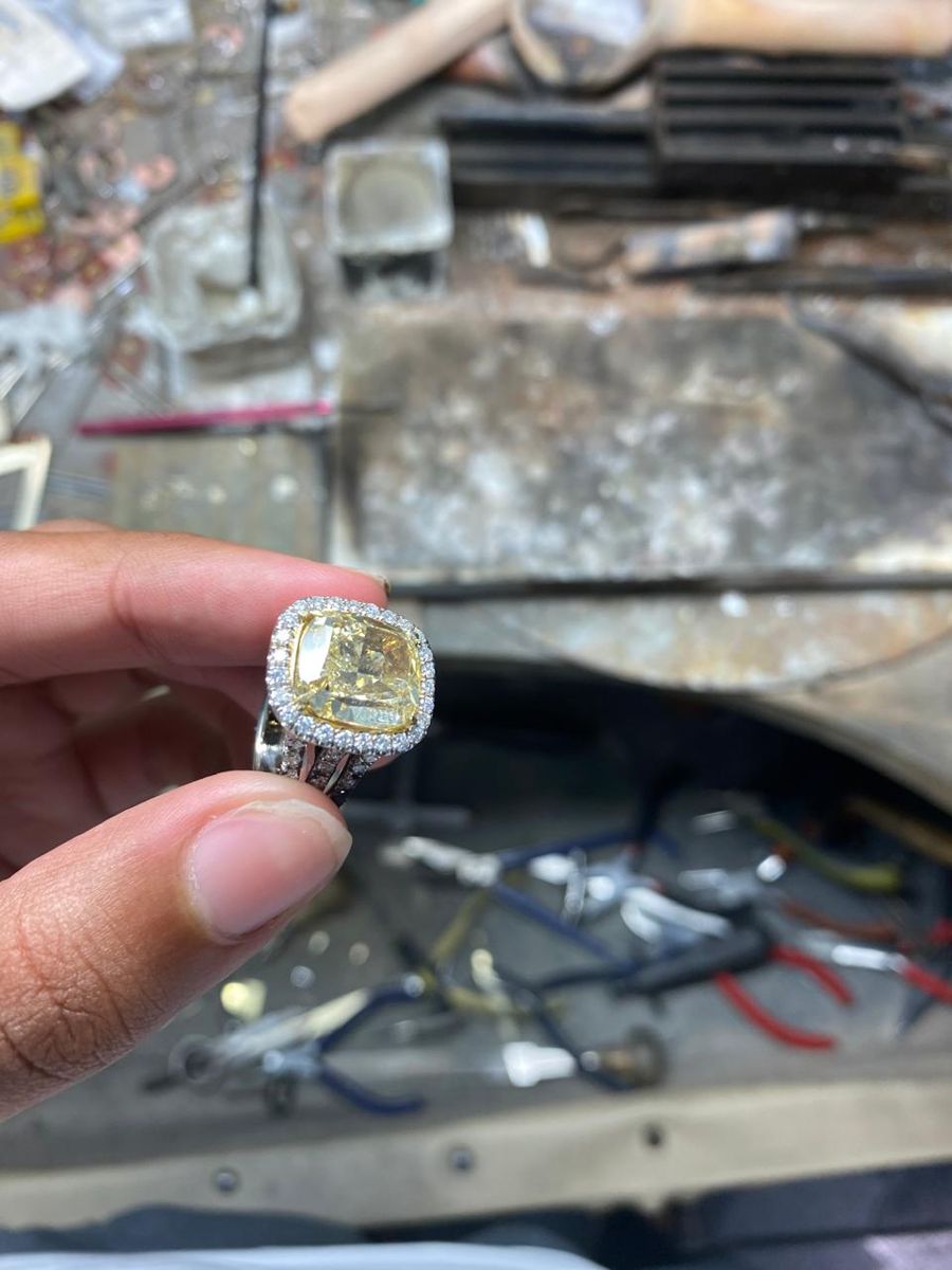 Close view of a cushion-cut yellow diamond set in a halo of small diamonds