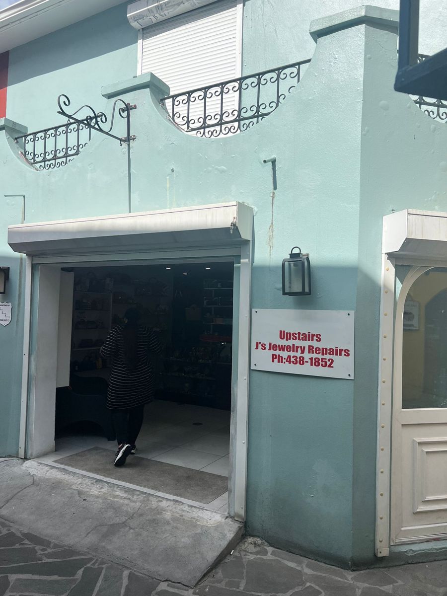 The open front of the shop, with the J's Jewelry Repairs Upstairs sign beside it